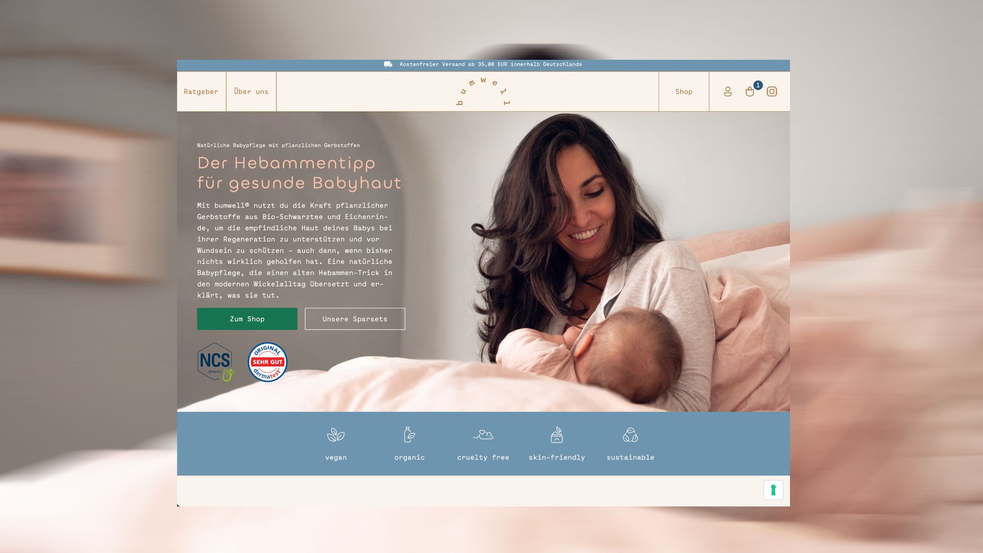The bumwell home page on a laptop, a mother smiling down at her nursing baby beside the headline “Der Hebammentipp für gesunde Babyhaut”